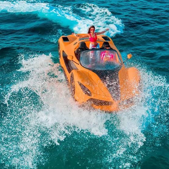 Jet car fuel: WaterBoatCar orange Ferrari-inspired jetcar powering through turquoise water at speed